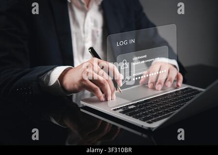 Businessman hand typing on laptop with virtual login interface showing username and password fields. Concept of secure user authentication, digital ac Stock Photo