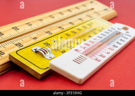 Selective Focus Perspective View of Three Analog Thermometers on Red Background Stock Photo