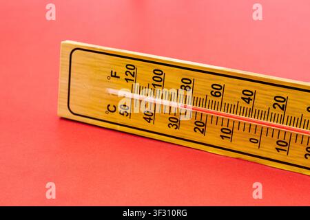 Macro Close Up Wooden Thermometer Measuring High Temperature on Red Background Stock Photo