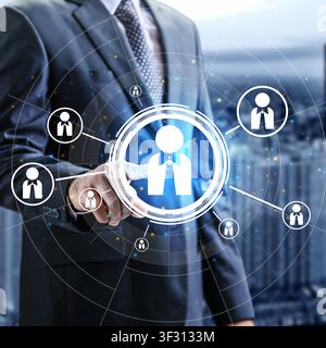 Businessman's hand interacts with a glowing digital interface showing human resources icons, representing recruitment, leadership, and team management Stock Photo