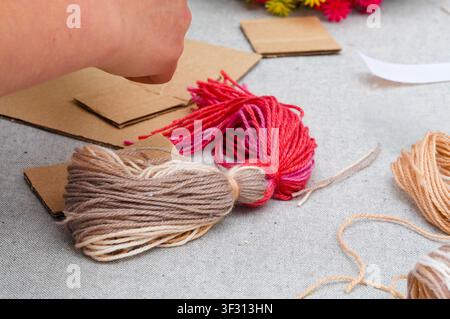 Handmade craft from yarn, scissors, thread and cardboard box. Stock Photo