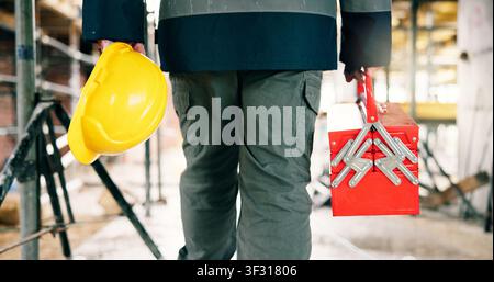 Tool box, helmet and construction worker on site with hands for equipment, safety and infrastructure upgrade. Renovation, contractor and person with Stock Photo