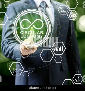 Businessman interacts with a holographic interface showing circular economy symbols and renewable energy icons, representing sustainable business prac Stock Photo