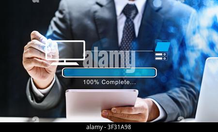 A professional businessman using a tablet and stylus to monitor a digital loading bar that is 100% complete on a virtual interface Stock Photo