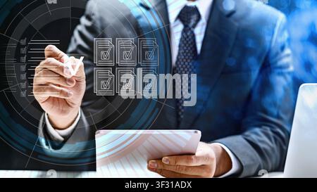 Professional businessman interacts with a digital interface showing document icons and checkmarks on a virtual screen, representing electronic signatu Stock Photo