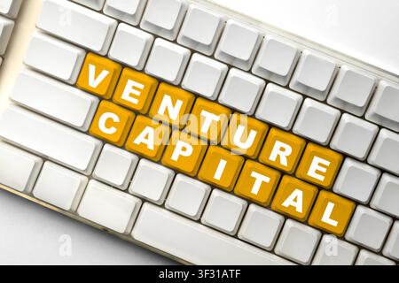 A close-up shot of a white computer keyboard featuring several orange keys that spell out the words Venture Capital, representing startup funding and Stock Photo