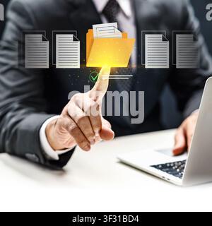 A businessman in a suit interacts with a virtual interface to manage digital documents and yellow folders, representing efficient data storage and off Stock Photo