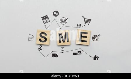 Small and Medium Enterprise (SME) concept shown with wooden blocks and various business icons like finance, logistics, marketing, and global trade on Stock Photo