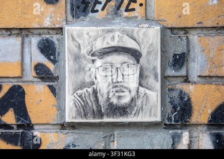 Ceramic tile portrait of a bearded man on yellow brick wall in Mitte district of Berlin, Germany Stock Photo