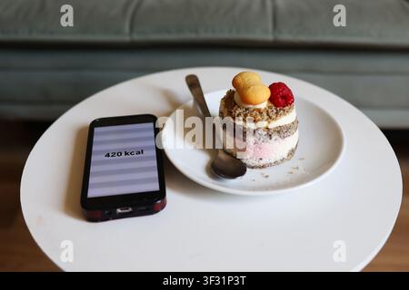 Top view of dessert beside a smartphone displaying calorie count, illustrating calorie tracking, mindful eating and healthy lifestyle. Stock Photo