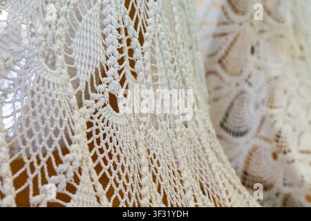 Textured background of a handmade white crochet doily or tablecloth with an intricate lace pattern. Stock Photo
