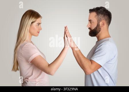 Focused Woman And Man Engaging In Connection, Touching Hands, Emotional Communication Concept Stock Photo