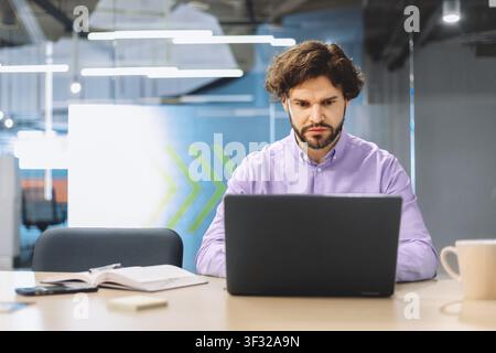 Man Working on Laptop at Desk in Office During Day Stock Photo