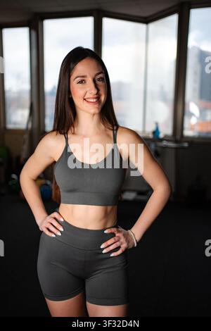 Young adult woman smiling posing in gym studio Stock Photo