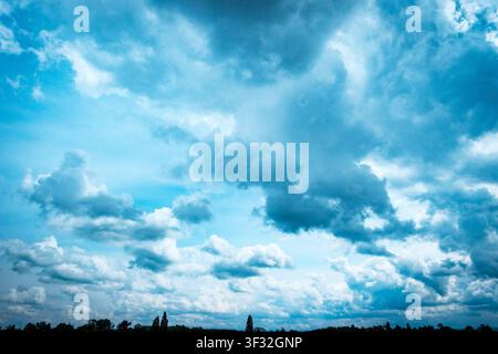 soft overcast cloud cover with pale blue openings, forming a moody vertical sky background with copy space. Stock Photo