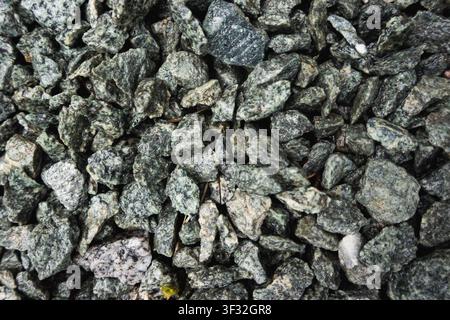 Top-down close-up of grey crushed stone and gravel with varied angular shapes, creating a rough construction aggregate texture Stock Photo
