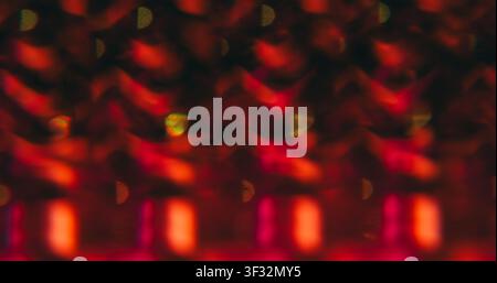 Patterned effect. Blur lens gleam. Defocused red pink color flare flicker sparkle glimmer shine on abstract bokeh light art dark black background. Stock Photo