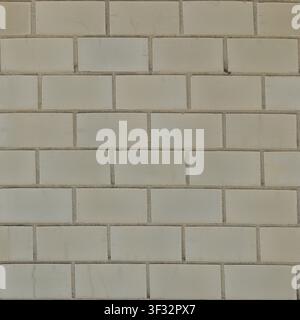 A clean off-white glazed subway tile wall texture with thin grey grout lines, featuring subtle surface crazing for a modern look. Stock Photo