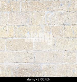A detailed texture of a light-colored sandstone masonry block wall. Stock Photo