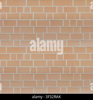A clean modern light orange brick wall texture featuring an alternating rectangular and square block pattern with white mortar. Stock Photo