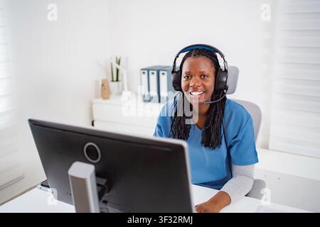 African American female nurse smiling providing telehealth service Stock Photo