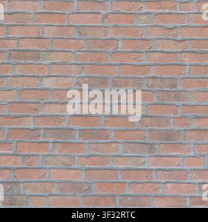 A rustic red brick wall with thick, prominent grey mortar joints in a running bond pattern, showing a weathered and traditional texture. Stock Photo
