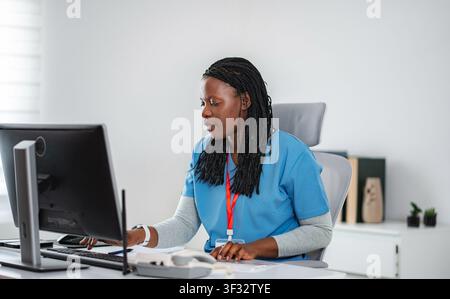 African American nurse working on computer in office Stock Photo
