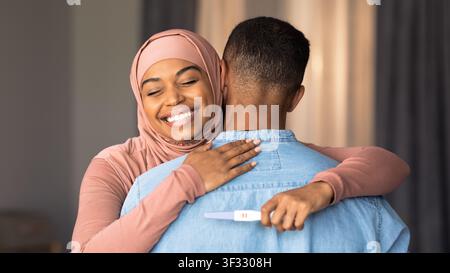 Happy Young Black Woman Sharing Exciting Pregnancy News With Partner At Home Stock Photo