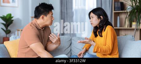 Couple Arguing And Having Conflict At Home, Asian Man And Woman, Tense Situation Stock Photo