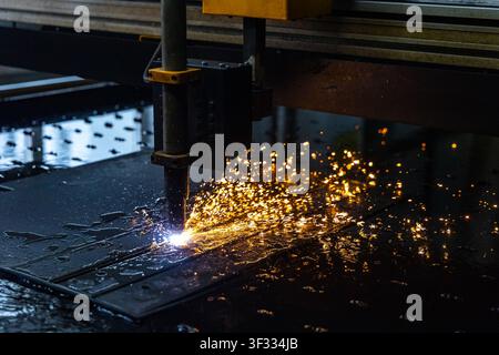 Automated CNC plasma cutting machine cutting steel with flying sparks Stock Photo