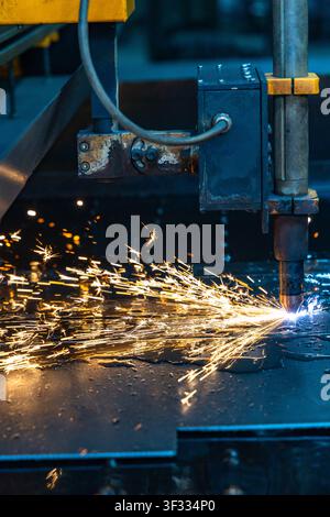 CNC plasma cutting machine cutting steel with bright sparks in factory Stock Photo