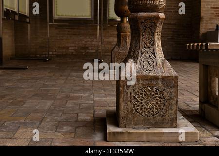Carved wooden column base with floral ornament inside Pahlavan Mahmud Mausoleum in Khiva, Uzbekistan. Detailed craftsmanship ideal for heritage, archi Stock Photo