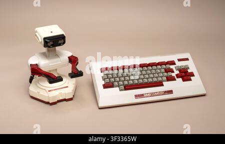 Pavia, Lombardy, Italy-March 30, 2026 : R.O.B. Robot standing next to a vintage Nintendo Family Computer keyboard from 80s Stock Photo