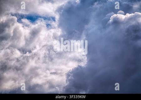 Striking contrast between bright illuminated clouds and deep dark storm clouds in a dynamic sky. Stock Photo