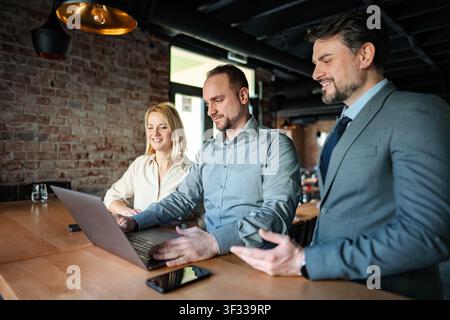 Business people collaborating on laptop during informal meeting Stock Photo