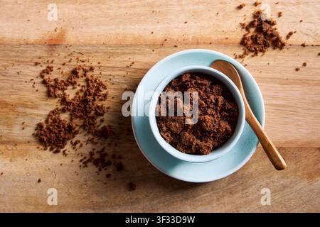 Dark muscovado sugar in a bowl with wooden spoon on rustic wooden table. Natural unrefined muscovado sugar for baking and cooking. Stock Photo