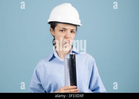 Thoughtful woman engineer holding building blueprint rolled documents Stock Photo