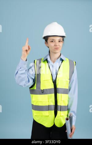 Confident woman worker pointing index finger upwards in building site Stock Photo