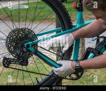 A digital chain wear indicator tool to measure elongation and check for stretch on a mountain bike chain during routine maintenance. Stock Photo