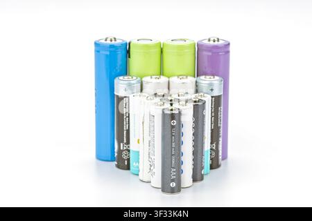 Collection of old used AAA and AA rechargeable batteries standing upright on clean white background Stock Photo