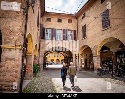 Senior couple enjoying an afternoon stroll through a historic arched alleyway with cobblestone paving and traditional architecture during a trip to Mo Stock Photo