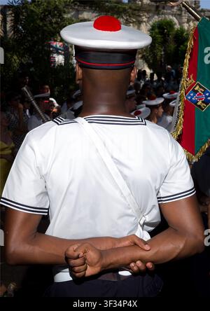 Rear view of French Navy sailor standing with hands clasped behind his back while attending formal outdoor ceremony, Arles, France Stock Photo
