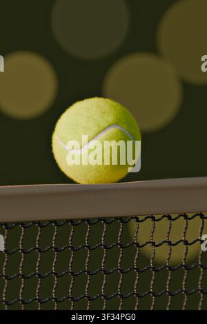 Close up of neon yellow tennis ball on professional stadium net with soft bokeh lights,3d render Stock Photo