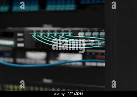 Network Server Rack with Patch Panels and Fiber Optic Cabling in Data Center Stock Photo