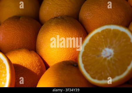 Whole and sliced oranges showing fresh fruit textures and bright colors Stock Photo