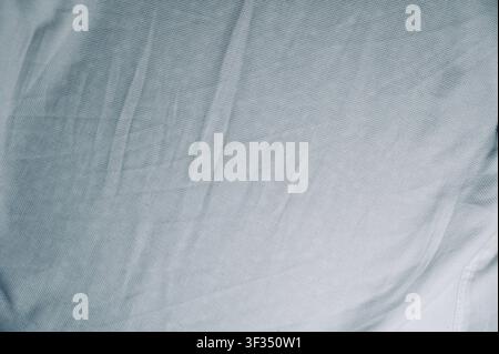 White Textured Cotton Fabric Texture with Soft Folds Background. High quality photoClose-up view of soft crumpled white woven fabric texture showing rich pattern detail, natural folds, and soft shadows. Ideal background for fashion, textiles, martial arts gi fabric, minimalist design, or apparel concepts. Stock Photo