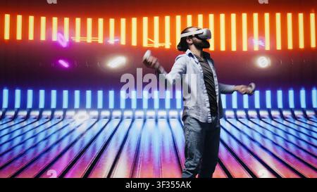 Artsy young guy immersed in virtual reality under neon lights and cyberpunk glow, blending street style with modern fashion and technology in a cool setting full of aesthetic visuals. Camera B. Stock Photo