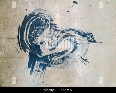 Blue paint messily splattering and spreading on a cracked gray concrete floor Stock Photo