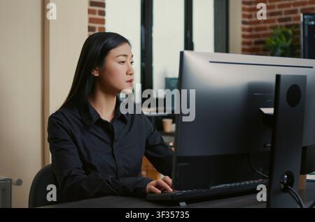 Programmer writes software code at an office desk, using computer screens, algorithms and database tools for digital application development. Stock Photo