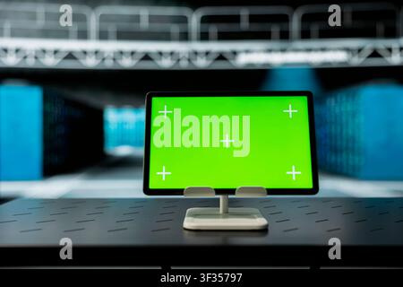 Close up of green digital tablet in high tech data center used to troubleshoot equipment rigs. Chroma key device in server hub running software development tools, resolving hardware errors Stock Photo